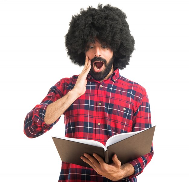 Surprised afro man reading book