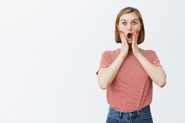 Free photo surprised and amazed young woman gasping from astonishment, say wow