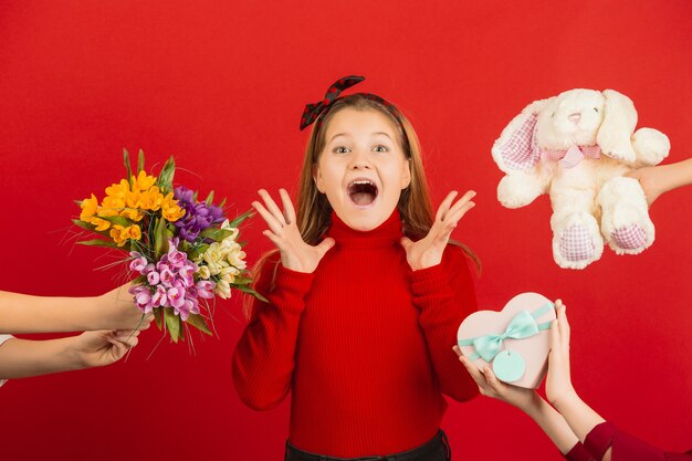 Surprised and astonished little girl receiving lots of gifts for Valentine's Day