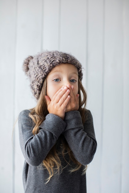 Surprised blonde girl with winter hat