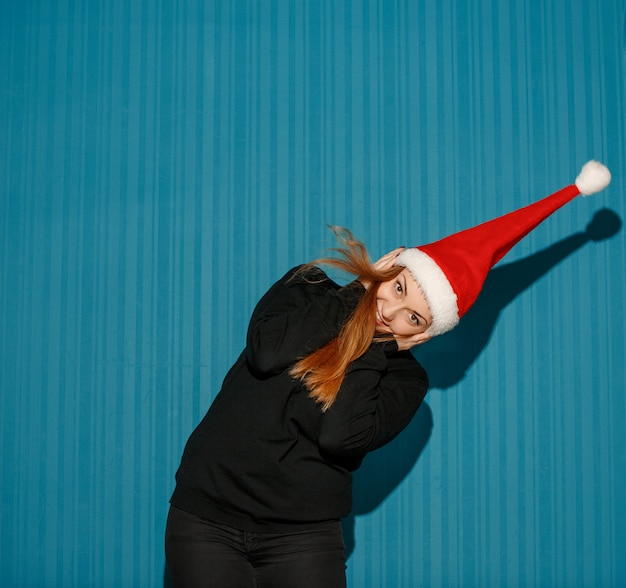 Free photo surprised christmas woman wearing a santa hat