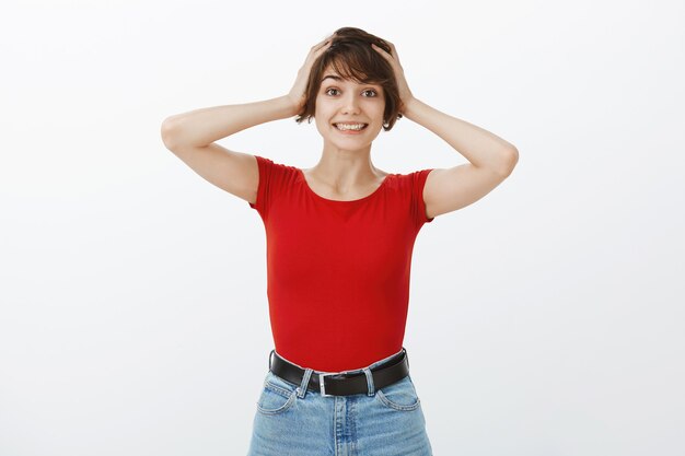 Surprised and excited woman grab head in amazement and smiling cheerful