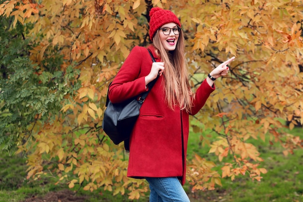 Free Photo surprised face. autumn park. pretty young  lady walking and enjoying nature.