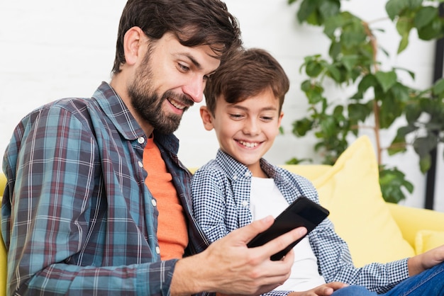 Surprised father and son looking on phone