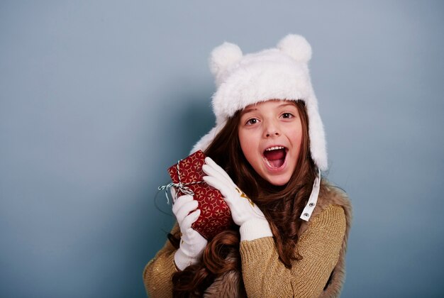 Surprised girl enjoying with christmas gift