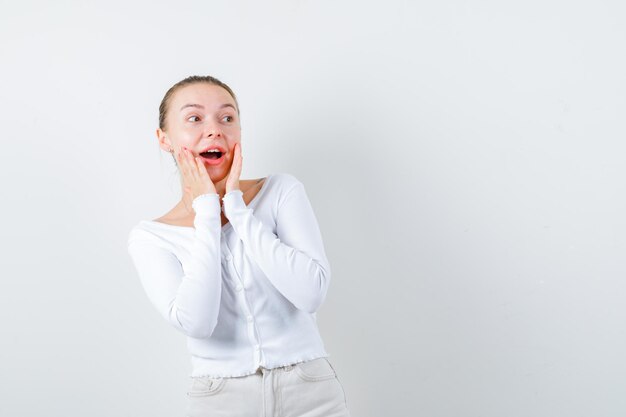 Surprised girl is looking at someone on white background