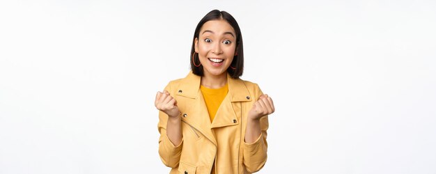 Surprised and happy asian girl looking with happy face of rejoice winning celebrating victory and tr