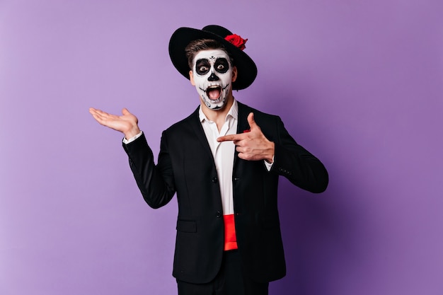 Free Photo surprised man in formal wear posing with zombie makeup. caucasian guy preparing for halloween in mexican style.