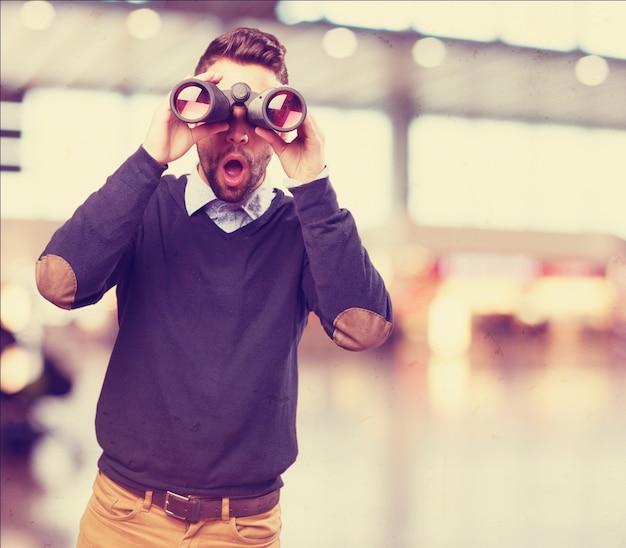 Free photo surprised man looking through binoculars