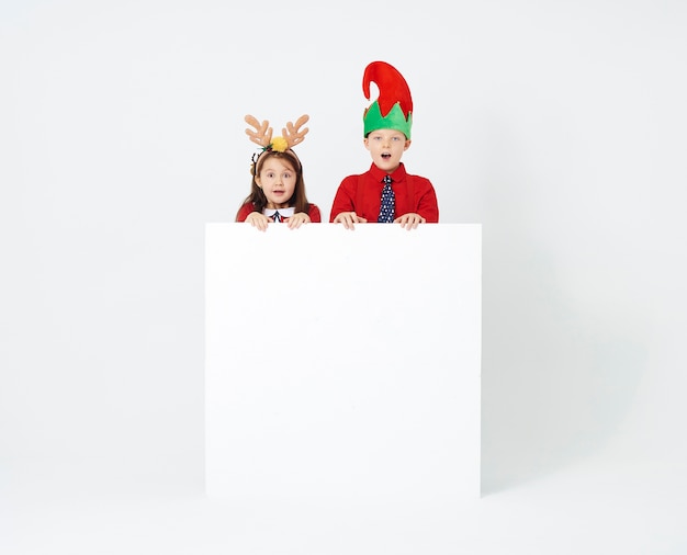 Free photo surprised siblings with banner at studio shot