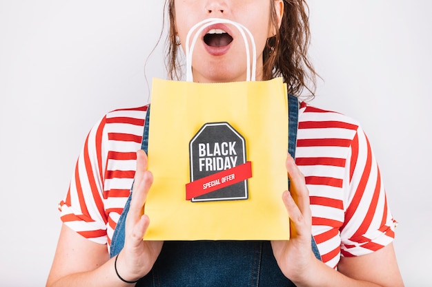 Free photo surprised woman holding holding black friday bag