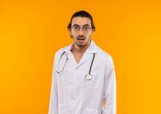 surprised young doctor with medical glasses wearing medical robe with stethoscope