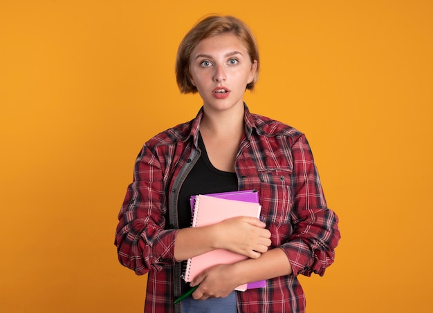 Free Photo surprised young slavic student girl holds book and notebook 