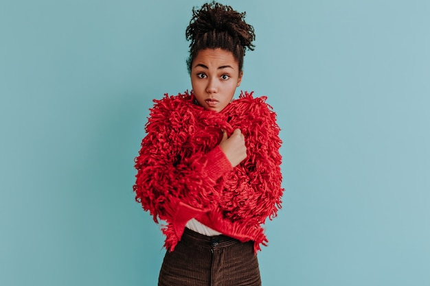 Free photo surprised young woman posing in red eco jacket