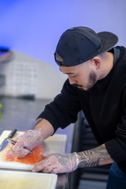 Sushi chef cutting fish and making sushi