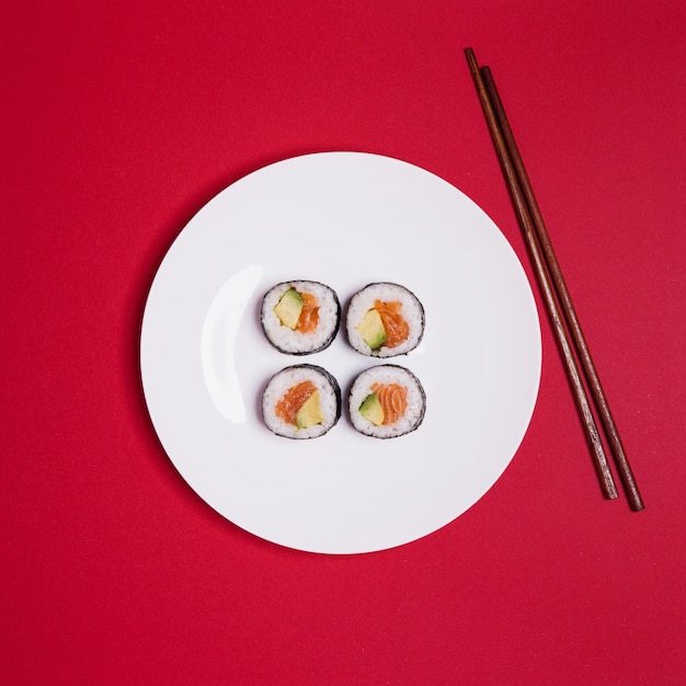 Free Photo sushi and chopsticks on red