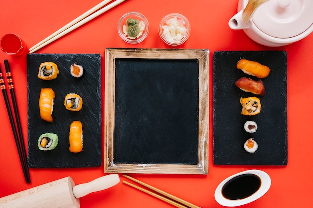 Free photo sushi and condiments around blackboard