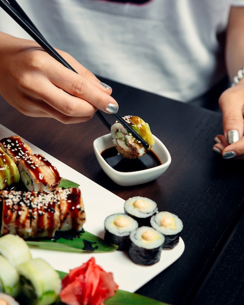 Free photo sushi rolls topped with sauce and sesame