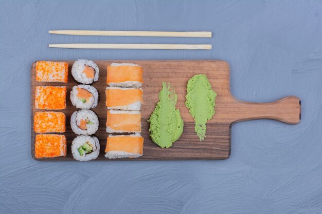 Sushi rolls with wasabi sauce on a wooden platter