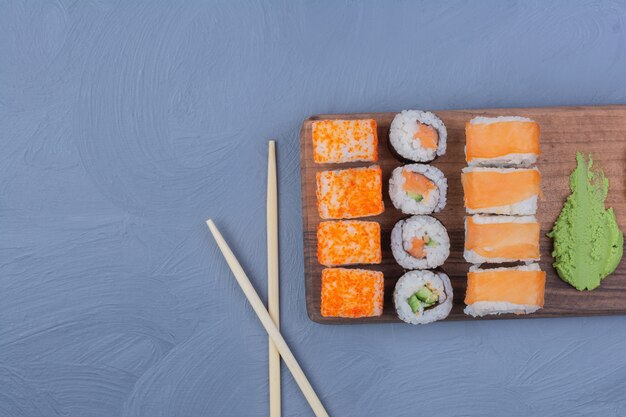 Sushi rolls with wasabi sauce on a wooden platter