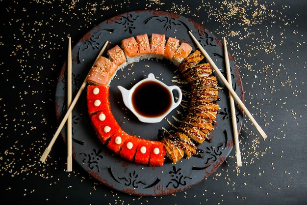 Sushi set with avocado, salmon, crab, sesame seeds and soy sauce