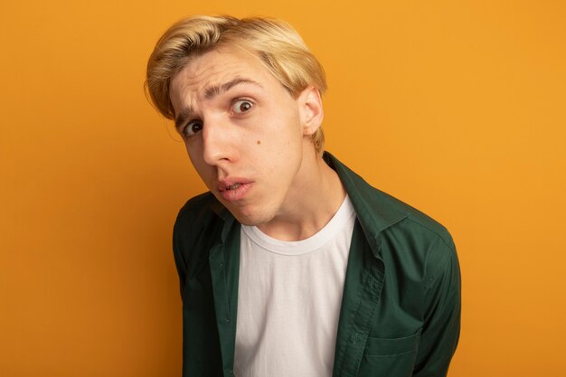 Suspicious young blonde guy wearing green t-shirt