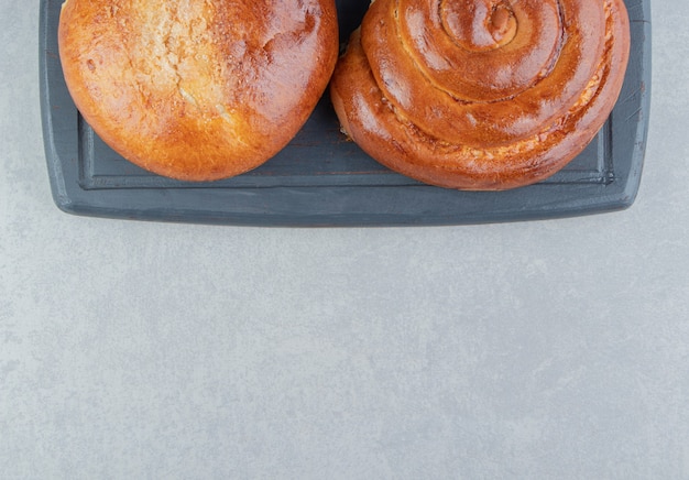 Sweet bun pastries on black board.