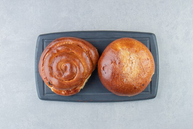 Sweet bun pastries on black board.