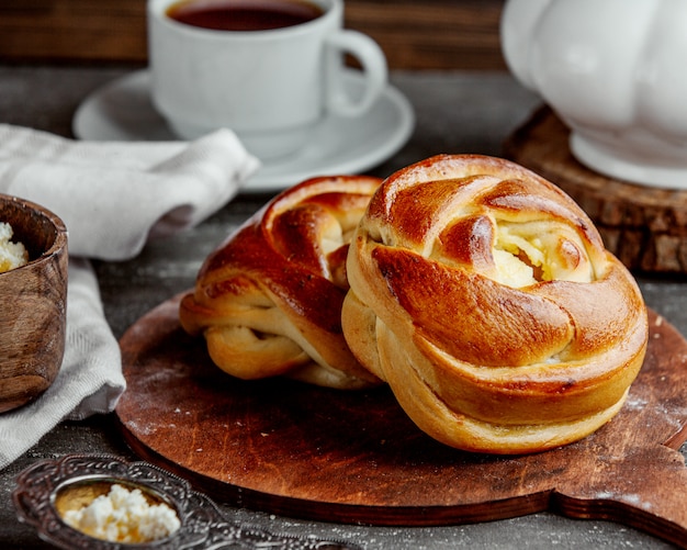 Sweet buns in rose shape served on wooden serving board