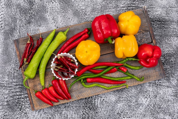 Sweet and chili peppers on wood cutting board