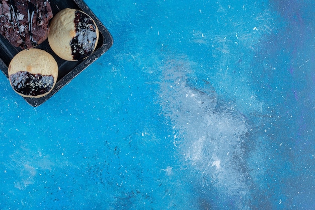 Sweet cookies on the board ,on the blue background . High quality photo