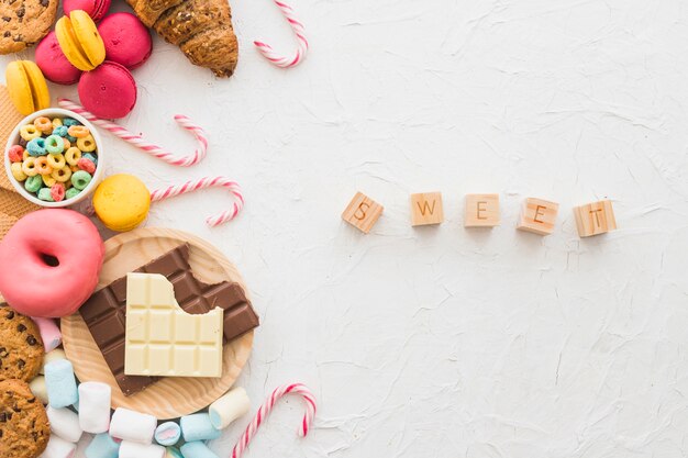 Sweet cubic blocks near unhealthy food on white backdrop