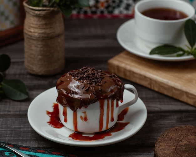 A sweet cup of tasty chocolate mousse with strawberry syrup inside