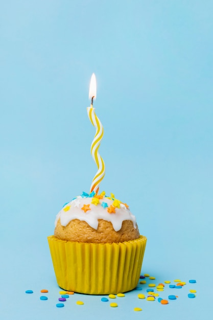 Sweet cupcake with a lit candle 