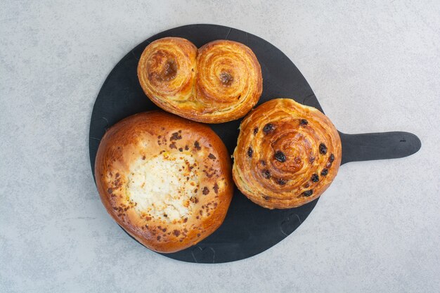 Sweet delicious pastries on dark board.