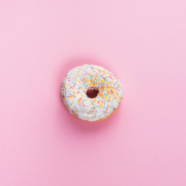 Free photo sweet glazed donut in center of pink background