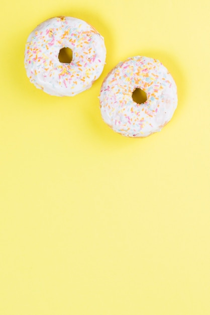 Free photo sweet glazed donuts decorated with colorful sprinkles