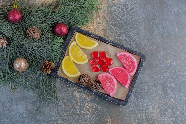 Free Photo sweet marmalades in dark plates with christmas pinecones . high quality photo