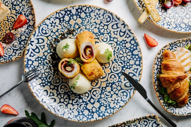 Sweet pastry rolls with vanilla cream in decorative plate.