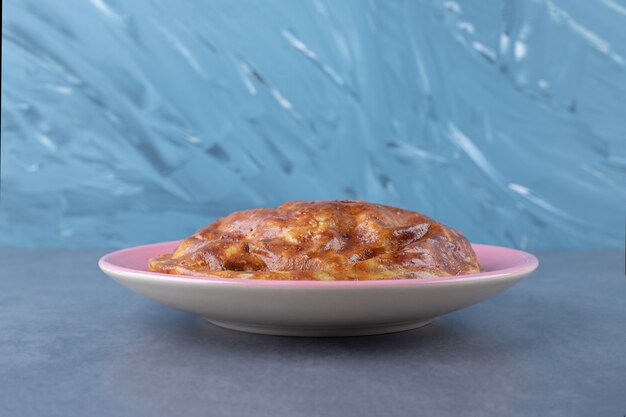 Sweet pie on a plate on marble table.