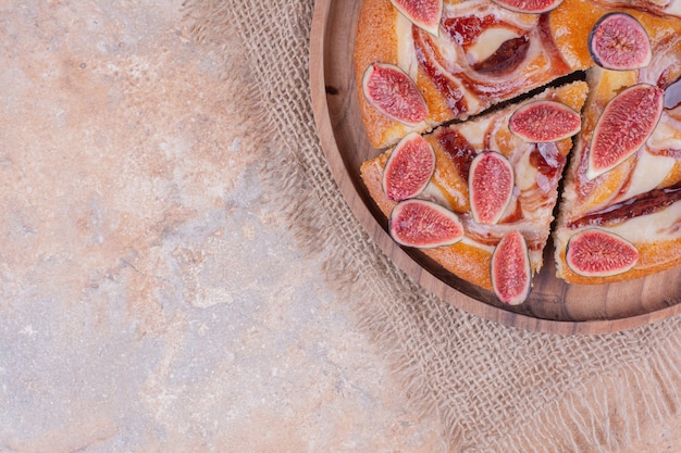 Free photo sweet pie with fig and caramel syrup on a wooden platter.