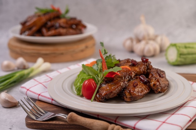 Free photo sweet pork in a white plate with chopped scallions, chili, lime, gourd, tomato and garlic.