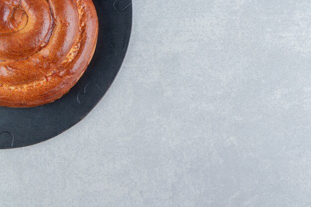 Sweet swirl bun on wood piece. 