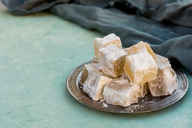 Free photo sweet turkish delight with cloth on blue table