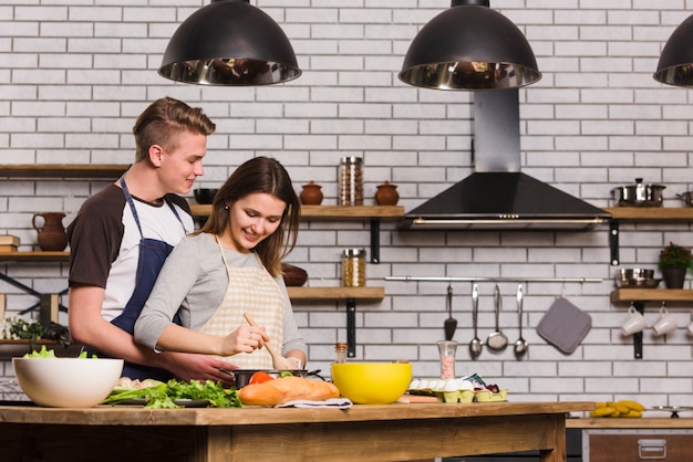 Sweethearts cooking at table in kitchen