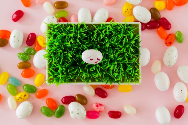 Sweets and eggs around pot with grass