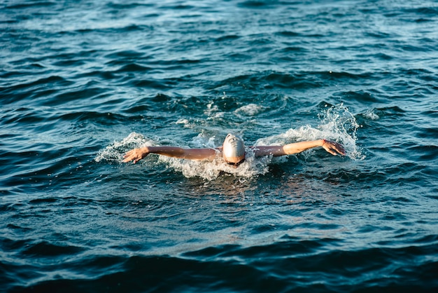 Swimmer with cap and goggles swimming in water