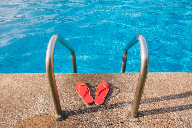 Free Photo swimming pool with ladder and flip flops