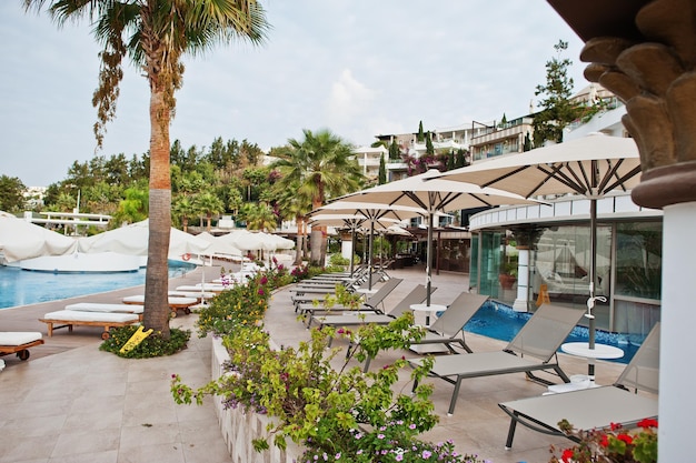 Swimming pool with sun beds in morning at mediterranean summer resort hotel in Turkey Bodrum