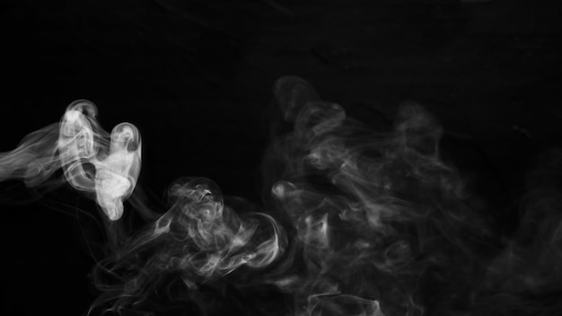 Free photo swirl of white smoke against black dark background